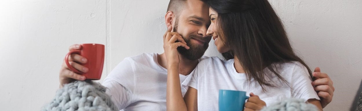 Liefhebbend stel met ochtendkoffie in bed