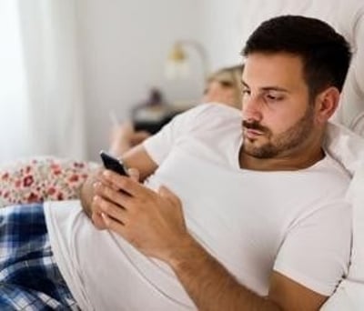 Een man schrijft stiekem tekstberichten op zijn mobiele telefoon
