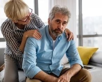 Een vrouw probeert haar verdrietige man op te vrolijken