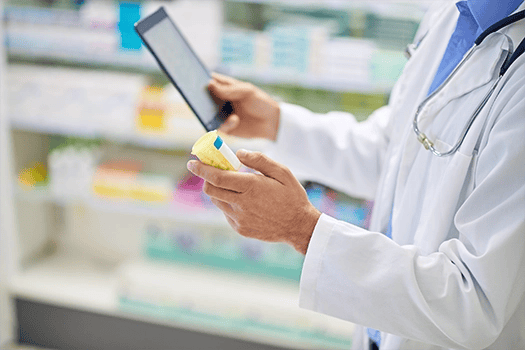 Een apotheker houdt een tablet vast